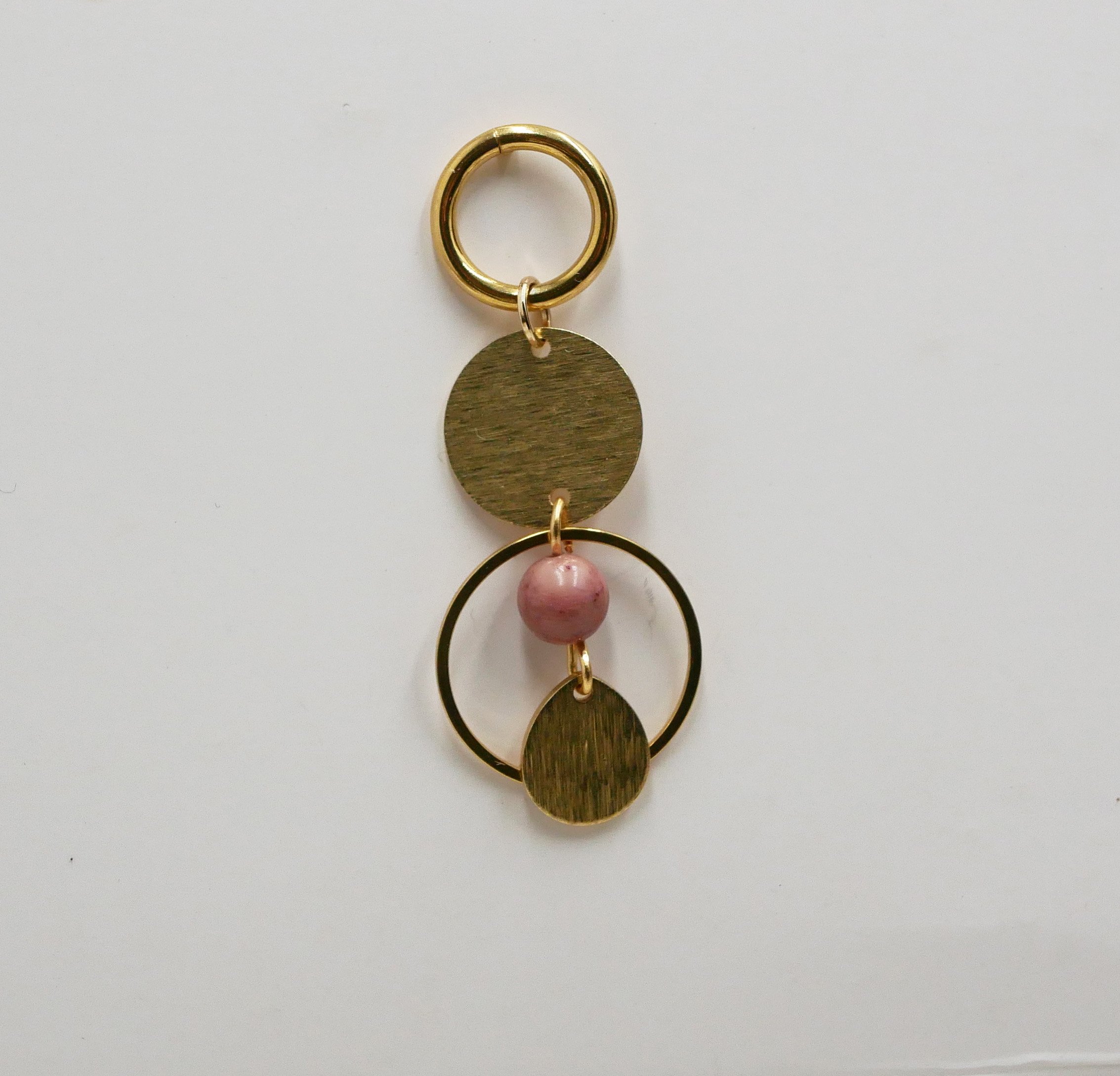 Solo oorbel met gouden hoepels en cirkels en roze Rhodoniet parel