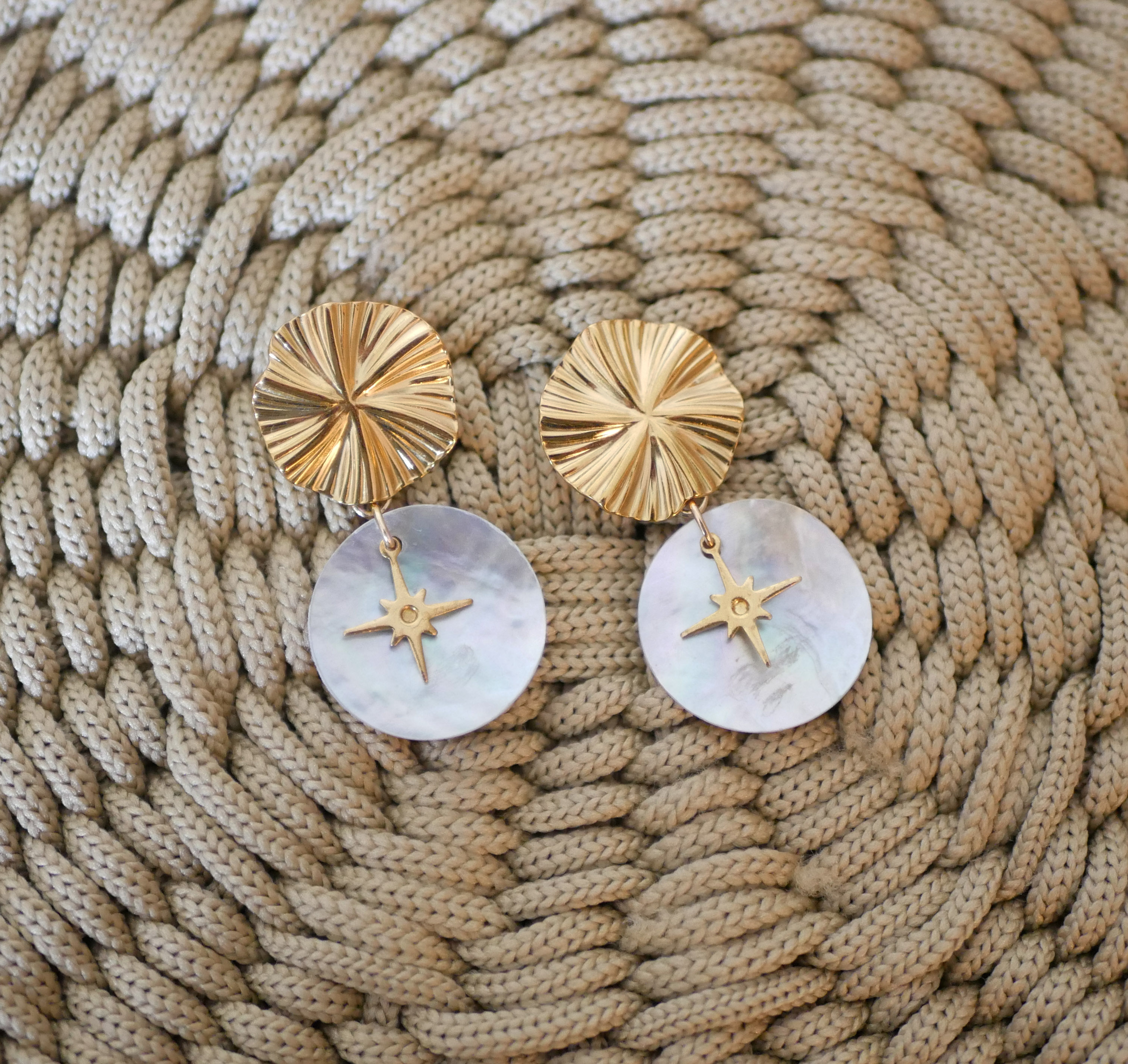Oorbellen uit de collectie "Les nacrées", gouden schijf met geplooid effect en windroos