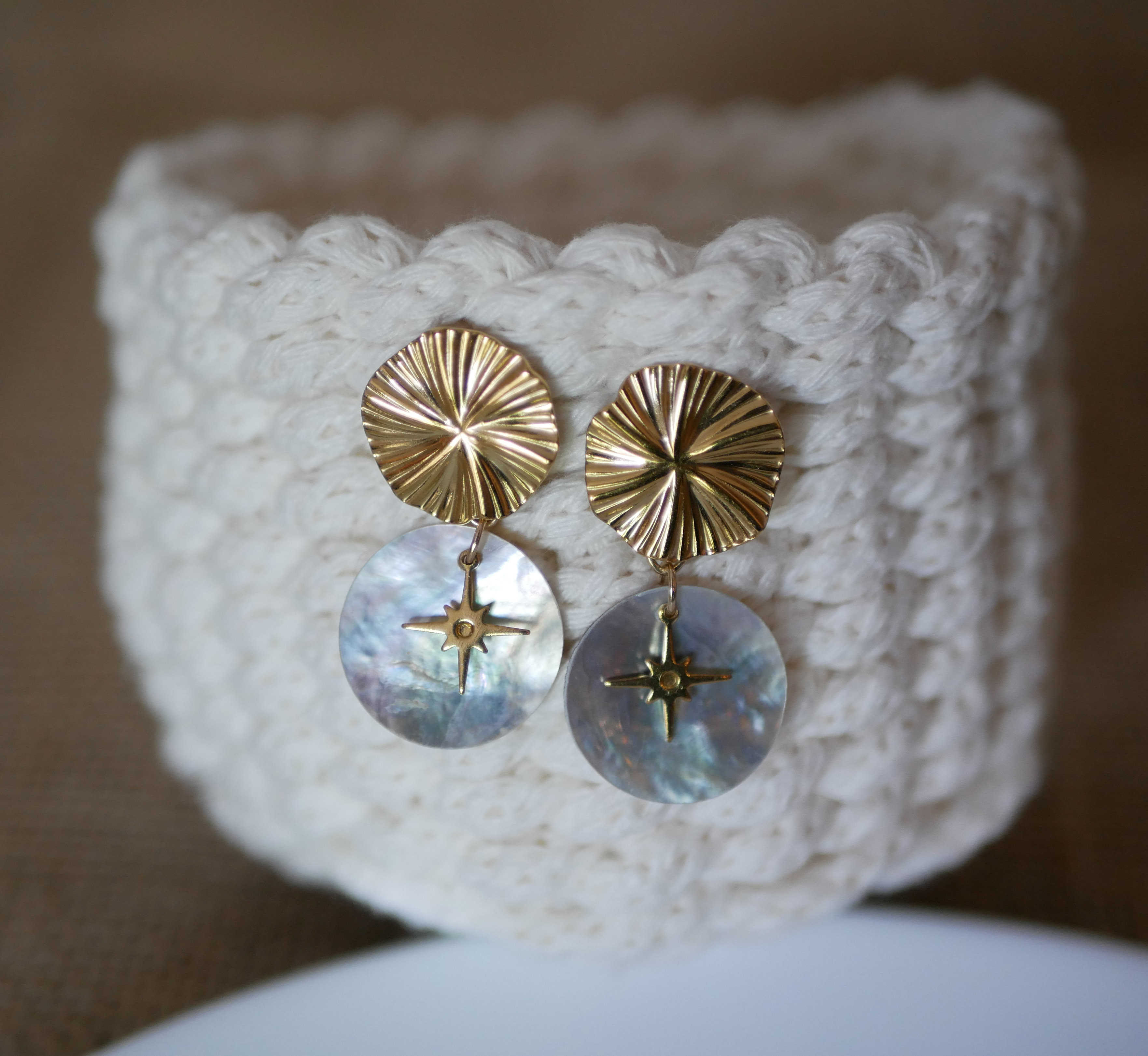 Oorbellen uit de collectie "Les nacrées", gouden schijf met geplooid effect en windroos