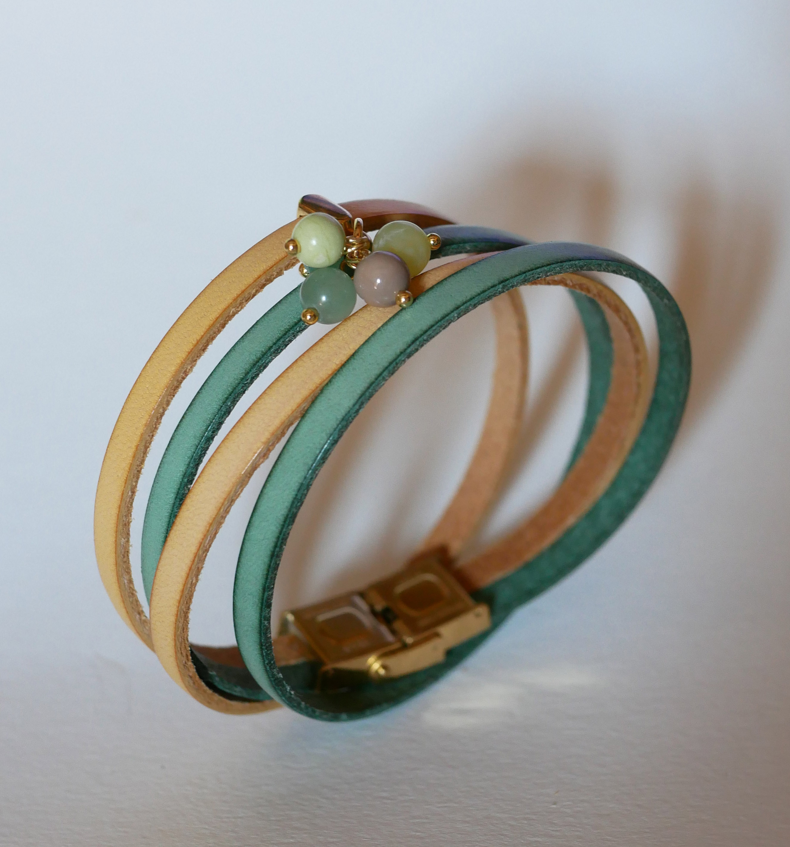 Dubbele leren armband versierd met zachtgroene parels en gouden sluiting