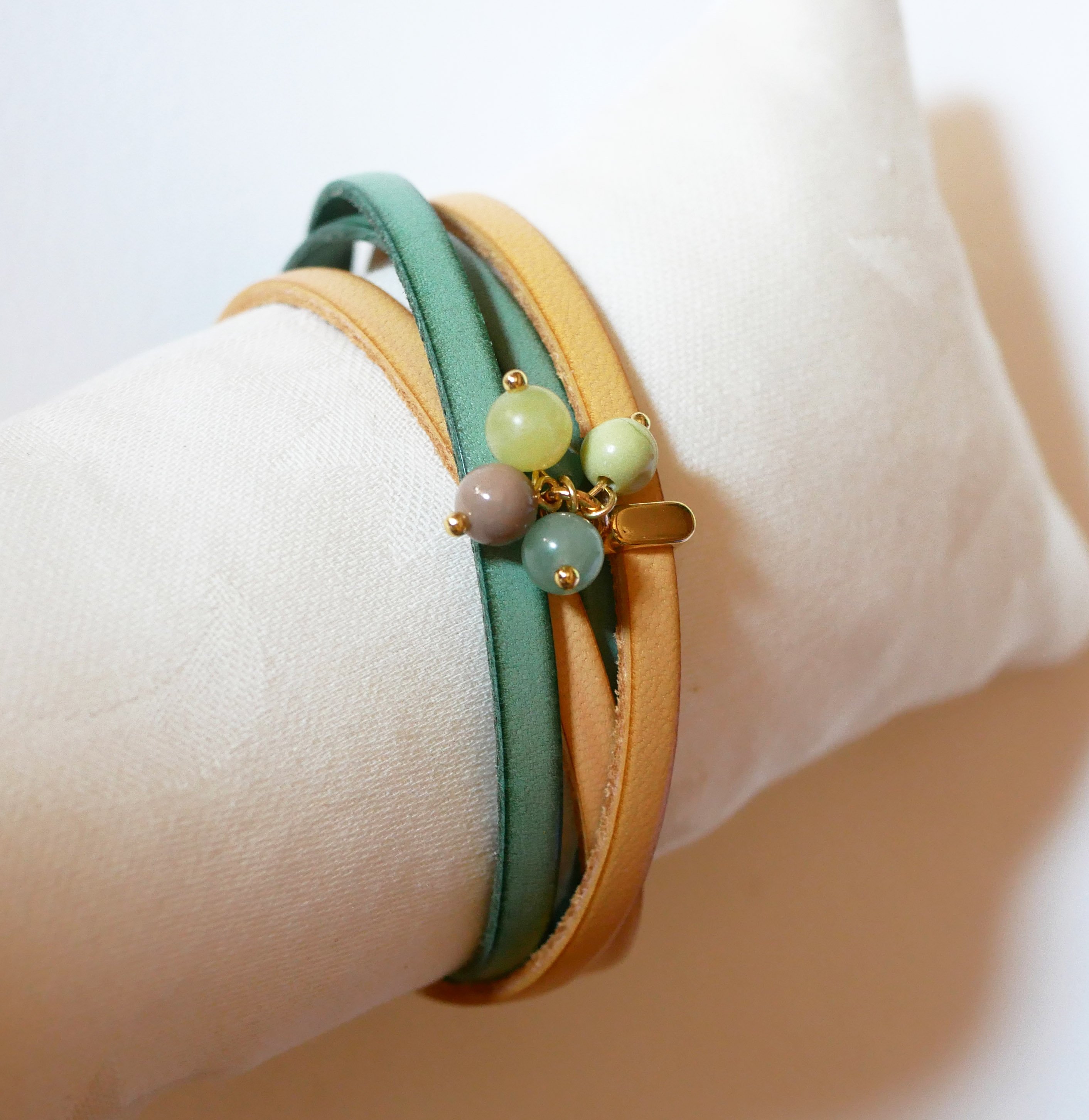 Dubbele leren armband versierd met zachtgroene parels en gouden sluiting