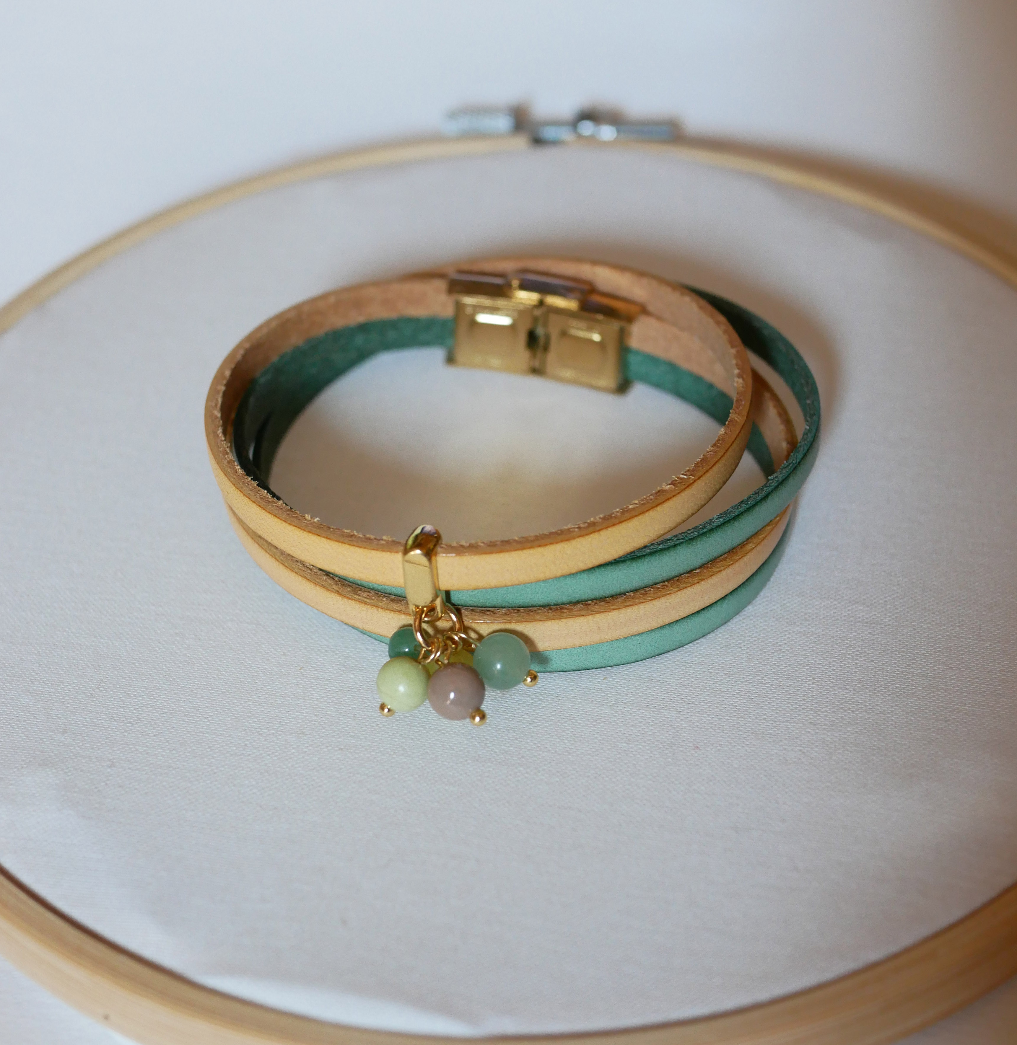 Dubbele leren armband versierd met zachtgroene parels en gouden sluiting