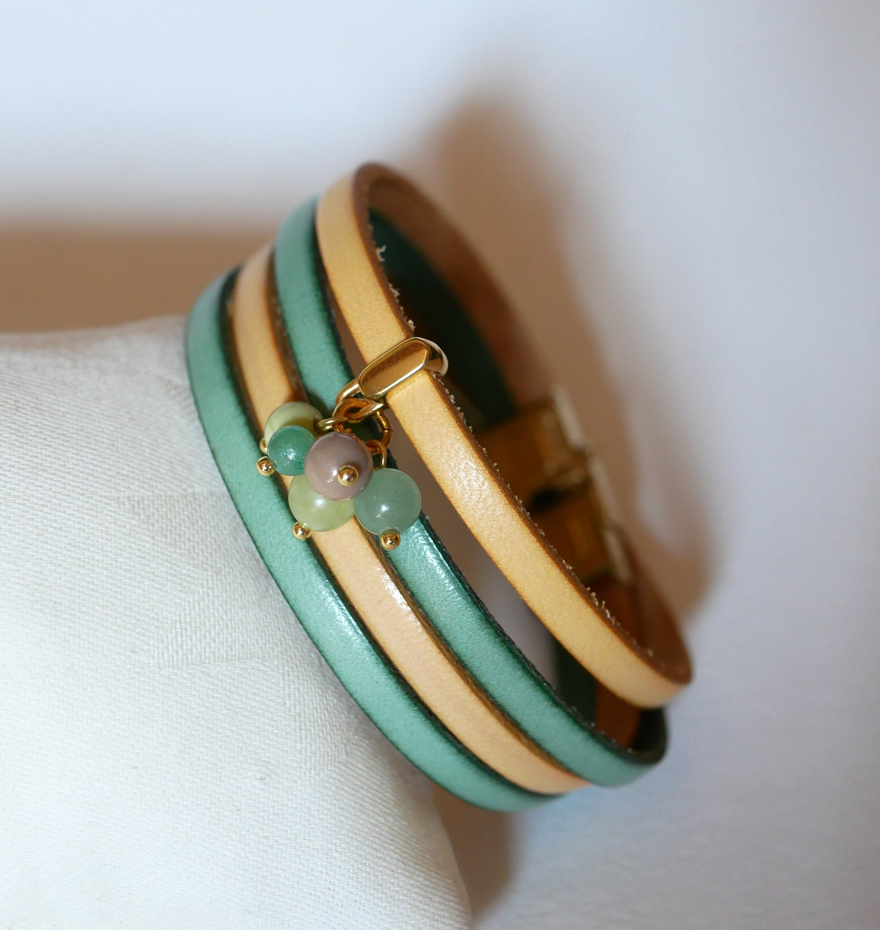 Dubbele leren armband versierd met zachtgroene parels en gouden sluiting