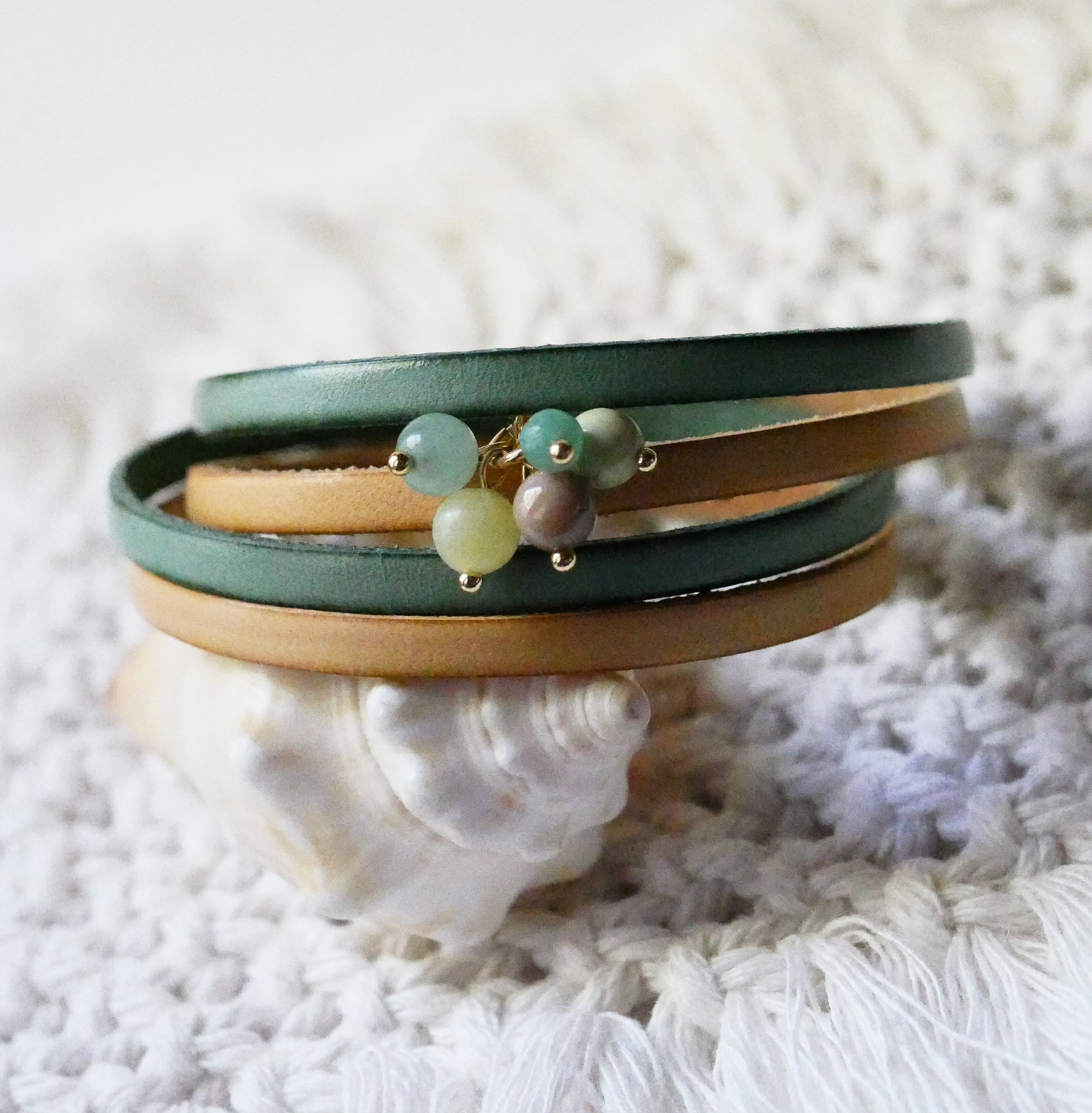 Dubbele leren armband versierd met zachtgroene parels en gouden sluiting