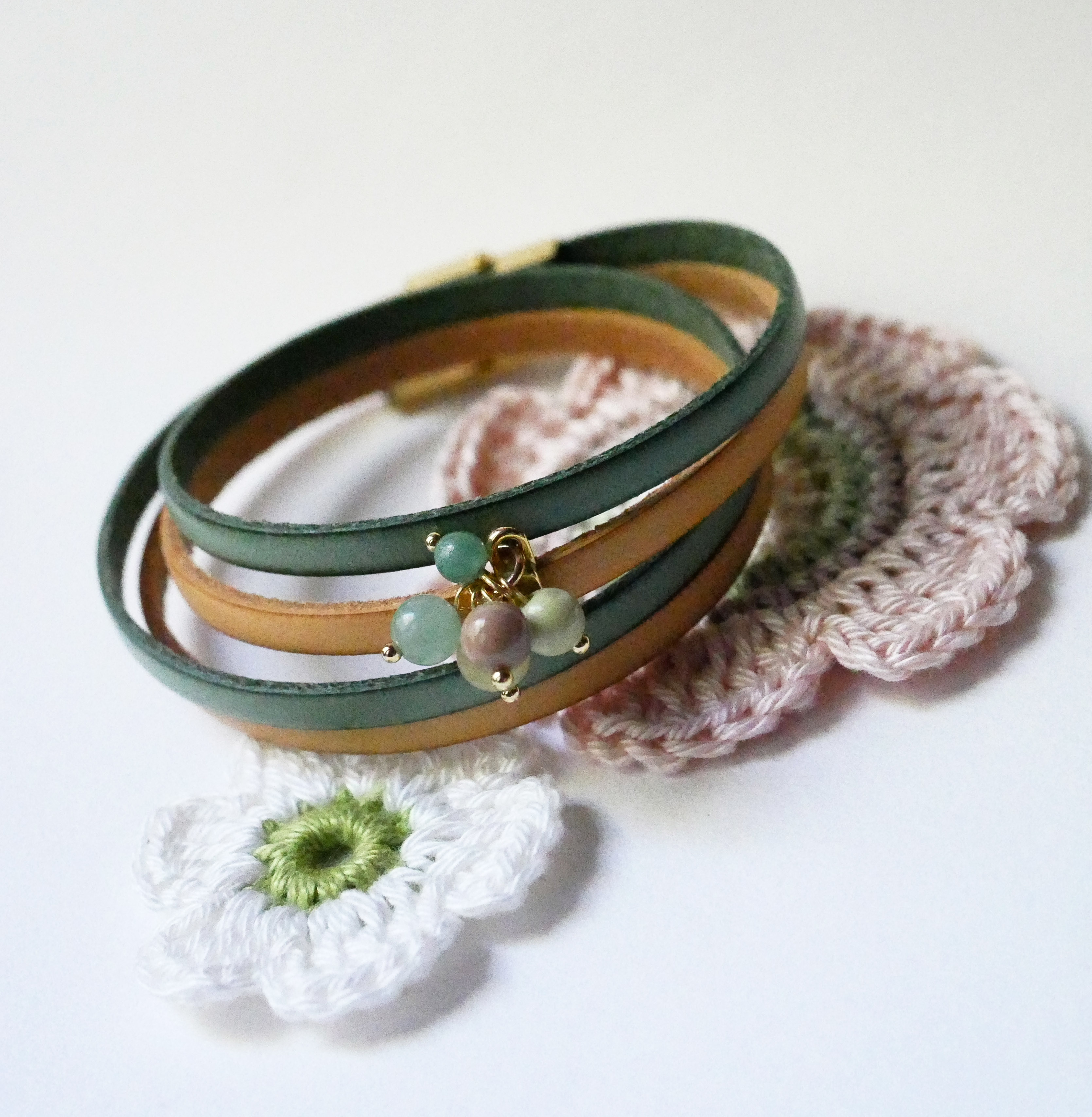 Dubbele leren armband versierd met zachtgroene parels en gouden sluiting