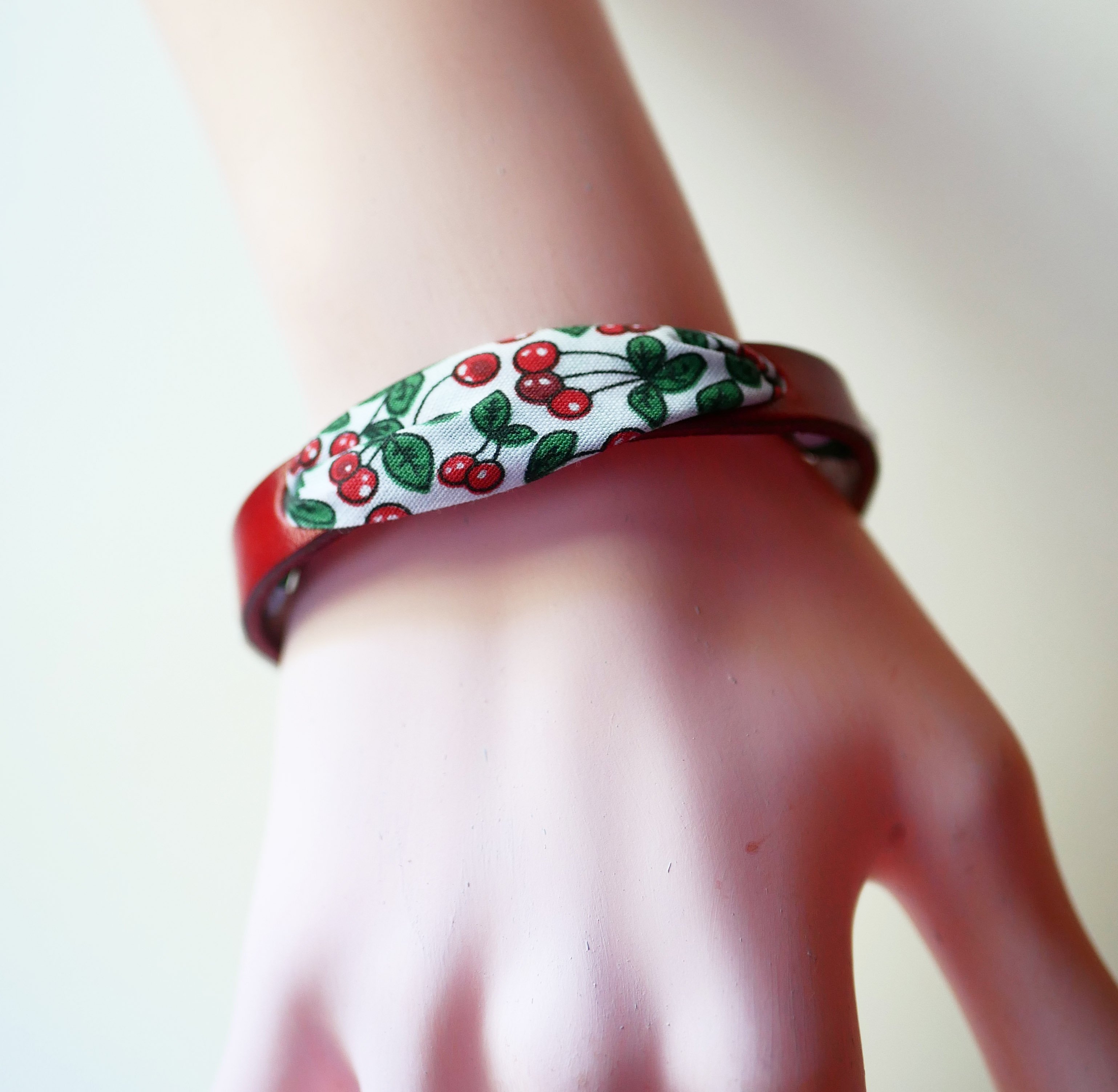 Florâme armband met lint van kersenvruchten op rood leer