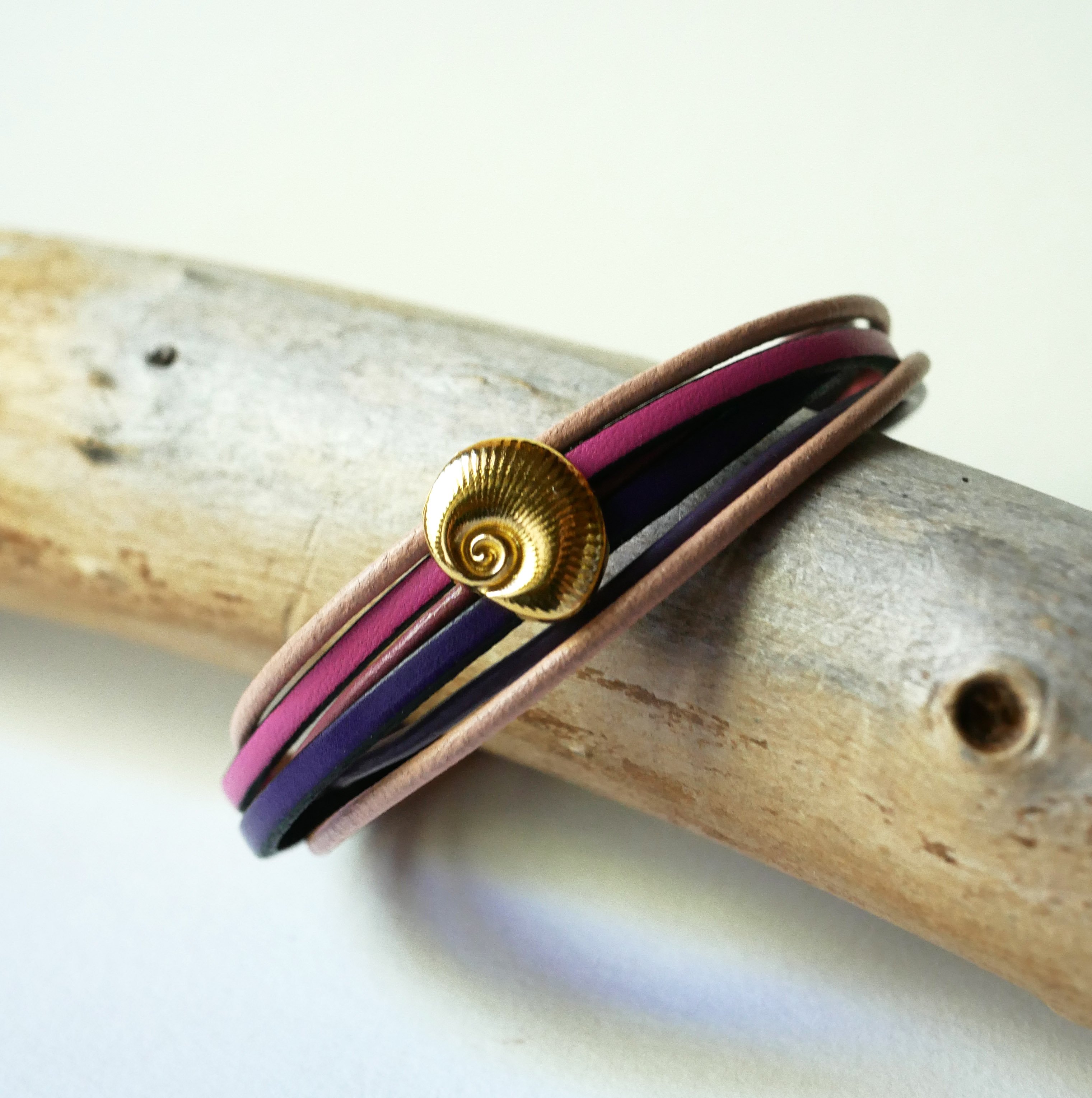 Multilink-armband van perzik- en mauveleer met goudkleurige schelpversiering