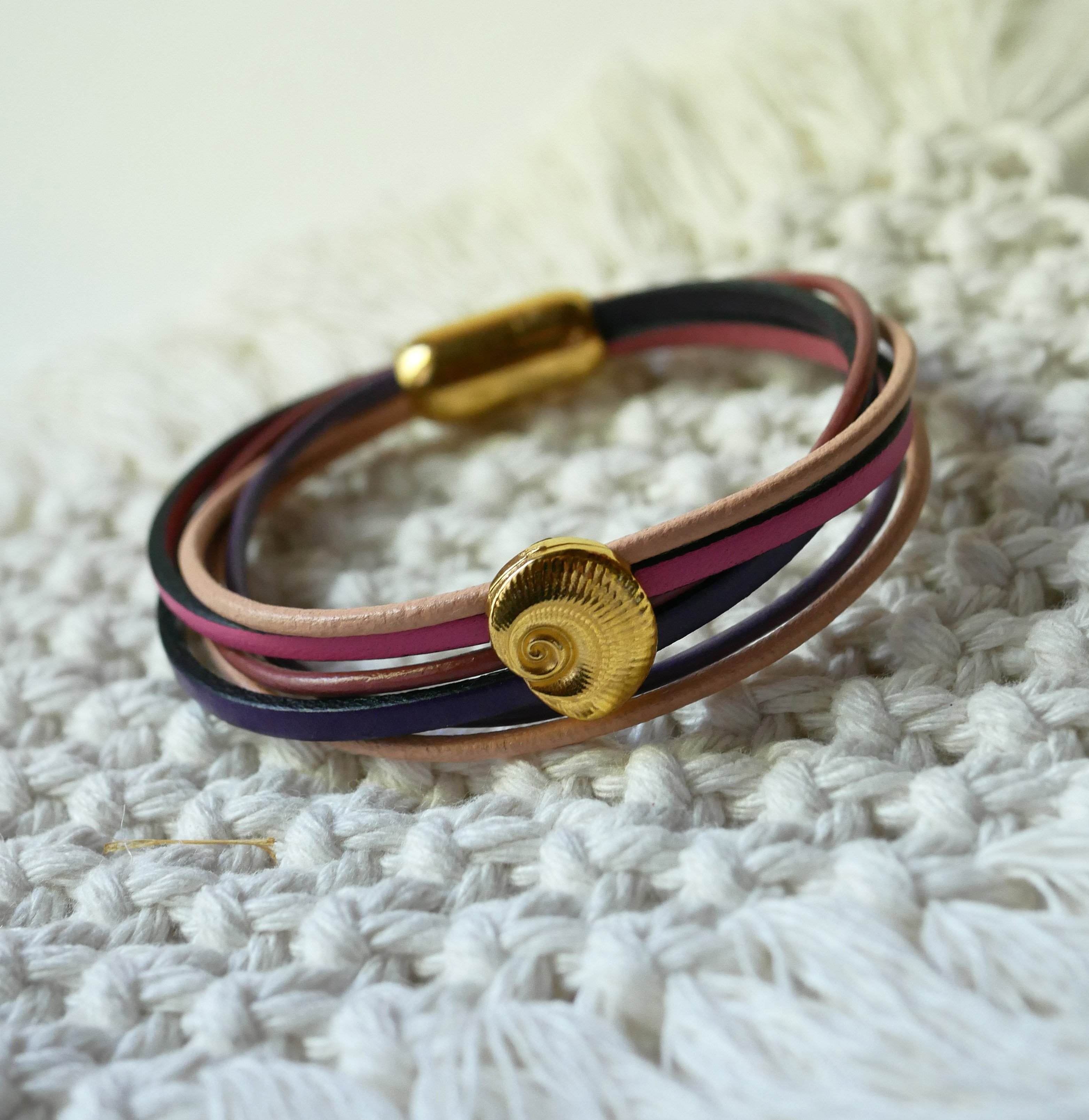 Multilink-armband van perzik- en mauveleer met goudkleurige schelpversiering