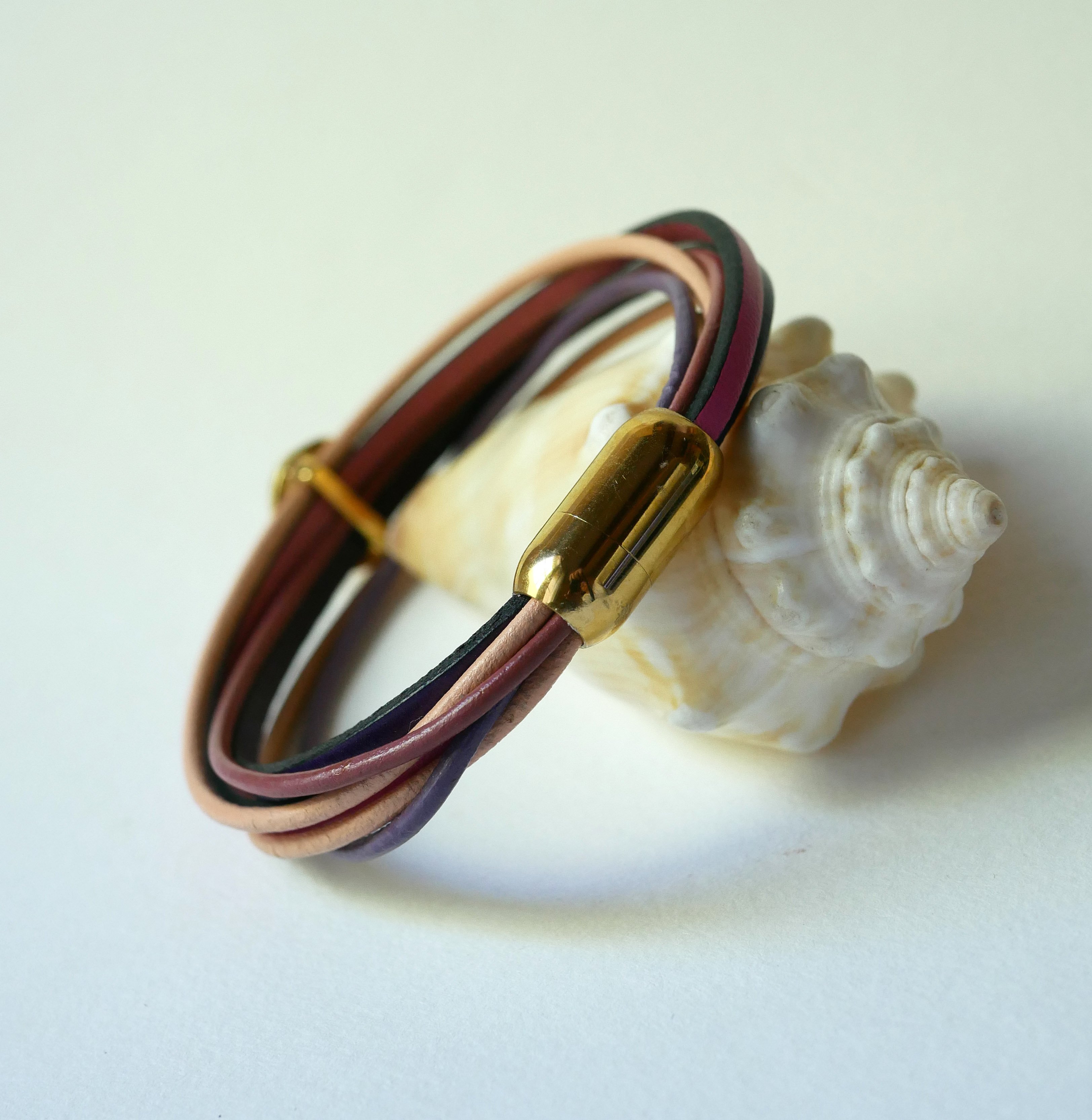 Multilink-armband van perzik- en mauveleer met goudkleurige schelpversiering