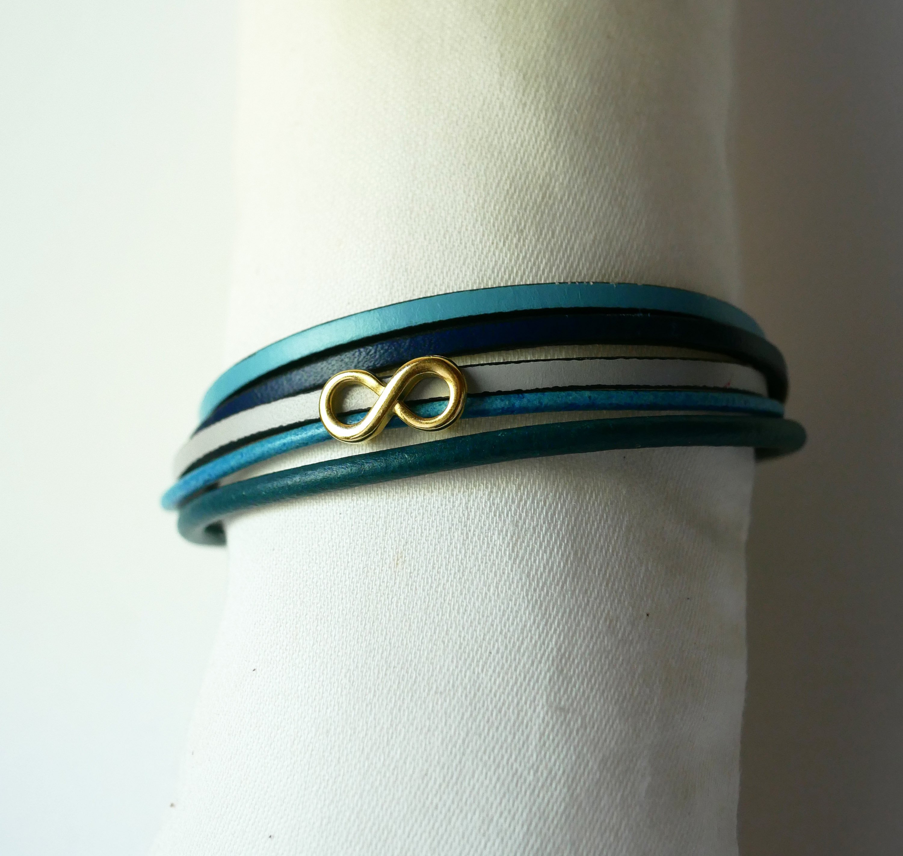 Multilink-armband van blauwkleurig leer met gouden infinity-motief