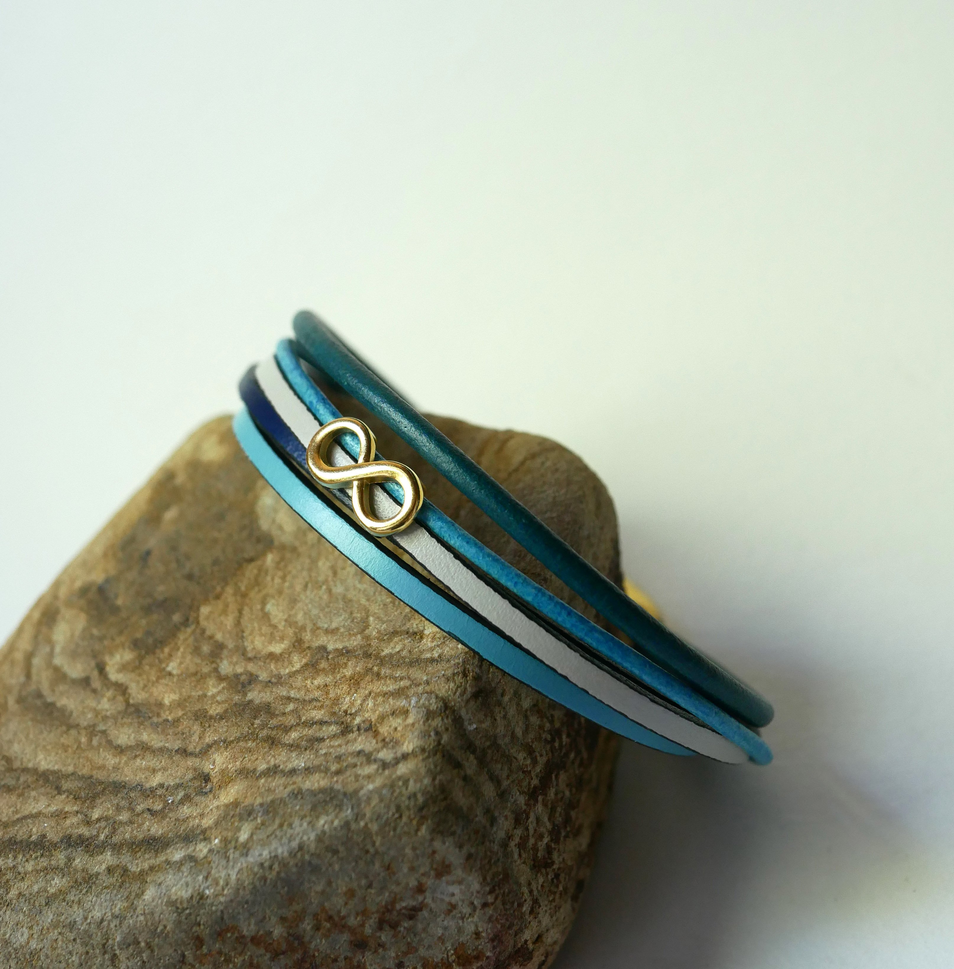 Multilink-armband van blauwkleurig leer met gouden infinity-motief