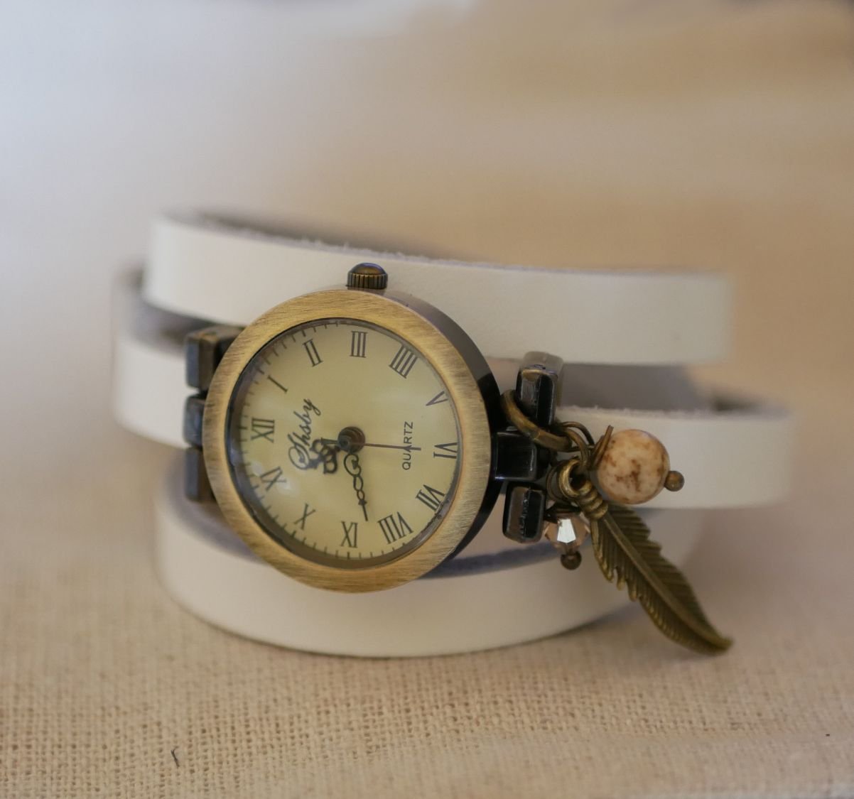 Leren armbandhorloge met veer- en parelbedels