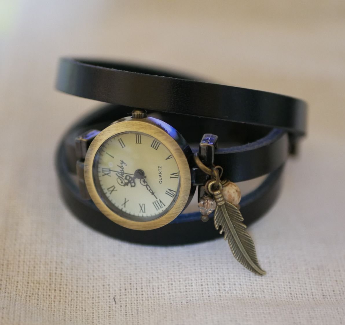 Leren armbandhorloge met veer- en parelbedels