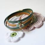 Dubbele leren armband versierd met zachtgroene parels en gouden sluiting